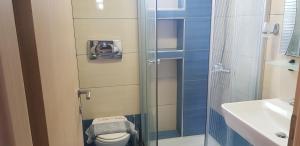a bathroom with a shower and a toilet and a sink at Hotel Oceanis in Kallithea Halkidikis