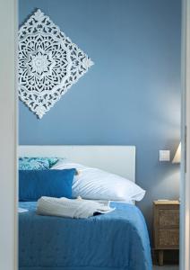 a blue bedroom with a bed with a blue wall at Ostraco Syros in Vari