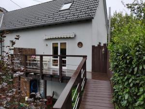 a small white house with a wooden deck at Maisonette Pablo in Gummersbach