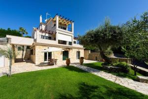 ein großes Haus mit grünem Rasen davor in der Unterkunft Luxury Corfu Villa Villa Jasmine Private Pool 4 BDR Dassia in Dafnila