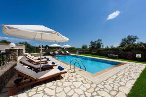 a swimming pool with lounge chairs and an umbrella at Luxury Corfu Villa Villa Jasmine Private Pool 4 BDR Dassia in Dafnila