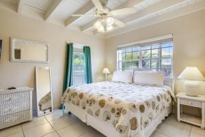a bedroom with a bed and a ceiling fan at Casa de Rosa in Key Colony Beach