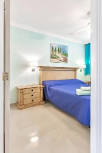ein Schlafzimmer mit einem blauen Bett und einem Nachttisch in der Unterkunft Luxury apartment Altamira in Adeje