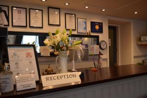 a reception counter with a vase of flowers on it at The Cameo in Blackpool