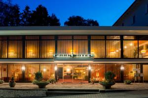 ein Gebäude mit großen Fenstern in der Nacht in der Unterkunft Parkhotel 1970 in Vielbrunn