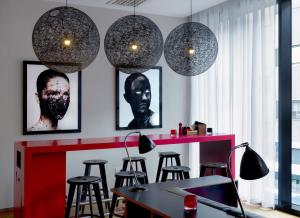 a room with a bar with stools and pendant lights at citizenM Glasgow in Glasgow