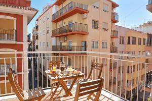 een balkon met een tafel en stoelen en een gebouw bij Luxury City Center Apartment by NRAS in Alicante