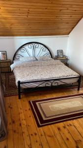 Bett in einem Schlafzimmer mit Holzboden in der Unterkunft Poiana dintre Brazi Chalet, Bucegi Panorama in Sinaia