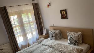 1 dormitorio con cama con almohadas y ventana en Poiana dintre Brazi Chalet, Bucegi Panorama, en Sinaia