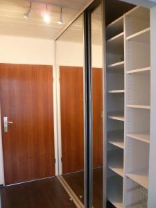 um closet com prateleiras de vidro e madeira em Apartment am Park em Dusseldorf