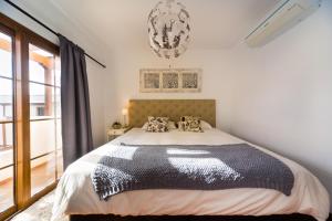 a bedroom with a bed with a black and white comforter at Aquavilla in Costa Teguise