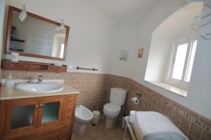 a bathroom with a sink and a toilet and a mirror at Apartamentos Altozano in Trujillo