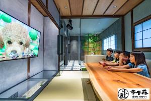 a group of children sitting around a table in a room with a tv at Konjaku-So Bentencho Osaka Bay -Universal Bay Area- in Osaka