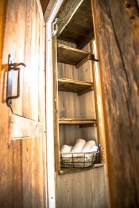 a wooden cabinet with a basket of white dishes at B&B LA VILLE CHAMOIS in Chamois