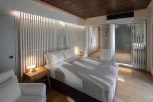 a bedroom with a bed and a chair and a window at Atrium Hotel in Agia Paraskevi