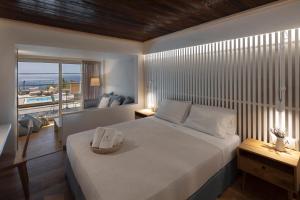 sypialnia z łóżkiem i widokiem na ocean w obiekcie Atrium Hotel w mieście Ajia Paraskiewi