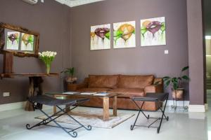 a living room with a couch and paintings on the wall at MalVille Boutique Hotel in Lilongwe