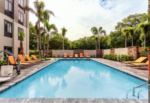 una piscina en un hotel con tumbonas y palmeras en Holiday Inn Express Tampa-Brandon, an IHG Hotel, en Brandon