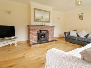 a living room with a fireplace and a couch at Hendre in Oswestry