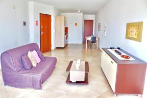 薩爾雷的住宿－Comfortable and spacious apartment with ocean views of Cabral beach，客厅配有紫色沙发和桌子