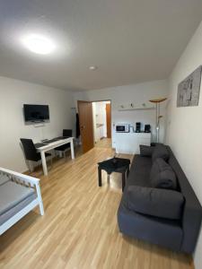 ein Wohnzimmer mit einem Sofa und einem Schreibtisch in der Unterkunft 1 Zimmer City Appartement mit Balkon in Göttingen