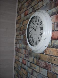 a clock is hanging on a brick wall at Hotel du Château in Nantes
