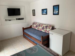 una pequeña sala de estar con sofá y TV en Residencial Varandas, en Florianópolis