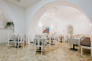 a room with white tables and chairs in it at Hotel Città di Parenzo in Trieste