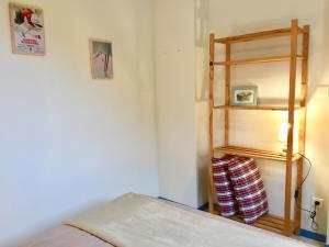 卢登维耶尔Appartement-Terrasse "Les Edelweiss" - Loudenvielle location的一间卧室设有一张床和一个木制架子