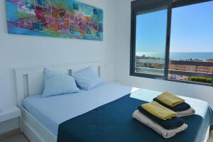 a white bedroom with a bed with towels on it at Penthouse with Panoramic View by NRAS in Santa Pola