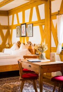 DER SCHWAN Hotel & Restaurant في Schwanstetten: غرفة نوم بسرير وطاولة وكراسي