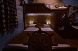 Un dormitorio con una cama de madera con una rueda. en El Volante, en Ciempozuelos