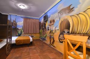 une chambre avec une fresque murale représentant un cowboy sur le mur dans l'établissement El Volante, à Ciempozuelos