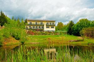 ein Haus auf einem Hügel neben einem Teich in der Unterkunft Coppertoppe Inn & Retreat Center in Hebron