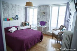 a bedroom with a purple bed and chairs and windows at Au Jardin des Deux Ponts in Abbeville