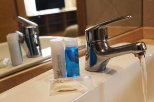 a bathroom sink with toothbrushes and toothpaste on it at Hotel Solans Riviera in Rosario