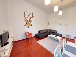 sala de estar con sofá y cabeza de ciervo en la pared en Deák Apartman, en Sopron