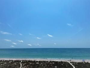 a view of the ocean with people on the beach at All Seasons Vacation Resort by Libertè in St Pete Beach