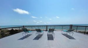 a group of chairs sitting on a balcony overlooking the ocean at All Seasons Vacation Resort by Libertè in St. Pete Beach
