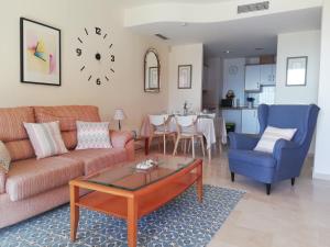 un soggiorno con divano, sedie e tavolo di Bonito y tranquilo apartamento , cerca del mar. a Torrox Costa