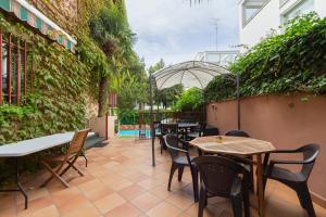 a patio with tables and chairs and an umbrella at Paraiso Rooms Coliving in Madrid