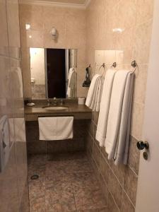 y baño con lavabo, espejo y toallas. en Pousada Ararinha Azul, en Campos do Jordão