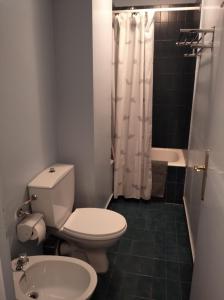 La salle de bains est pourvue de toilettes, d'un lavabo et d'une baignoire. dans l'établissement Apartamento en la Molina, à La Molina