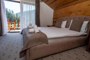 a bedroom with a large bed and a large window at Chalet Residence in Tatariv