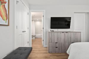 1 dormitorio con TV en una cómoda de madera en Escape Casey Key, en Nokomis