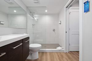 a white bathroom with a toilet and a shower at Escape Casey Key in Nokomis