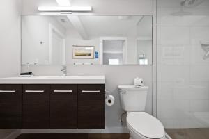 ein Badezimmer mit einem WC, einem Waschbecken und einem Spiegel in der Unterkunft Escape Casey Key in Nokomis