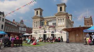 un gruppo di persone seduti di fronte a un edificio di Kingston Flat a Kingston upon Thames