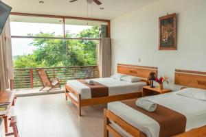 a bedroom with two beds and a balcony at Wasai Puerto Maldonado Eco Lodge in Puerto Maldonado