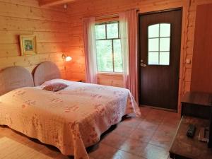 a bedroom with a bed in a wooden house at Tahkonhovi Golden Chalet in Tahkovuori